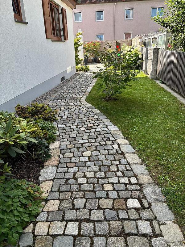 Geschwungener Weg aus Granit-Kopfsteinpflaster